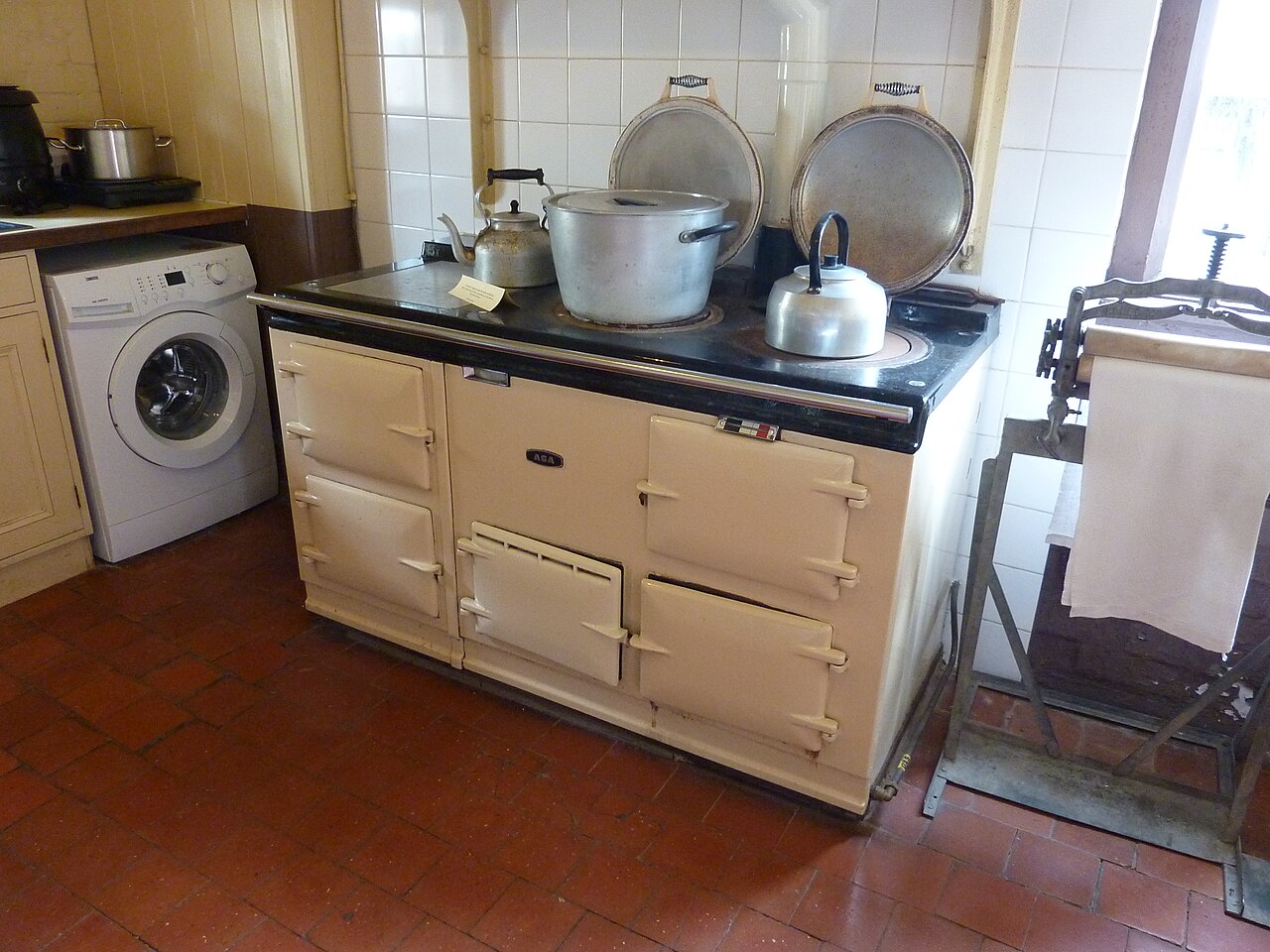 A cream Aga range cooker on a tiled kitchen floor