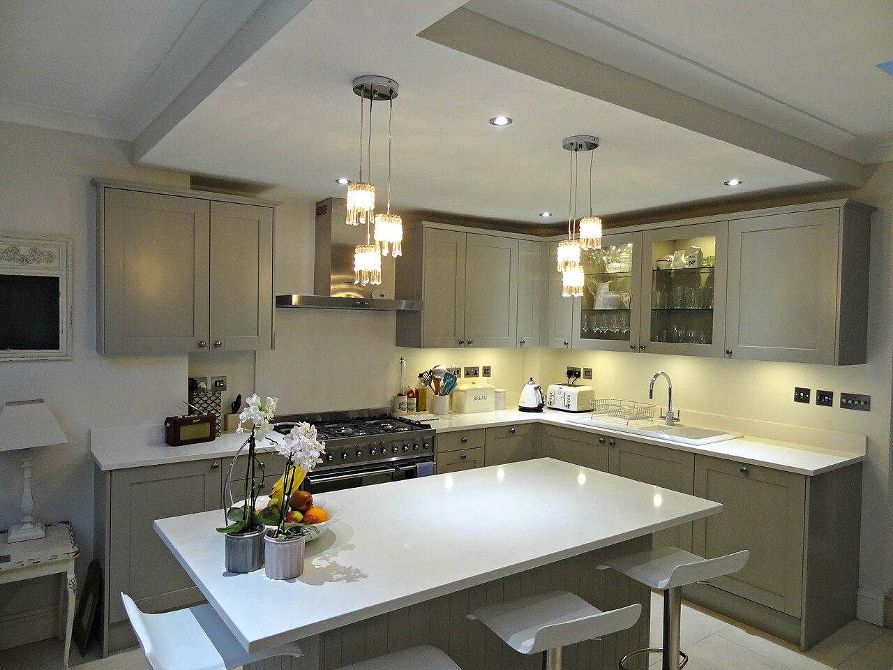 A handmade Shaker-style kitchen painted in soft grey-green, with an island, in Teddington